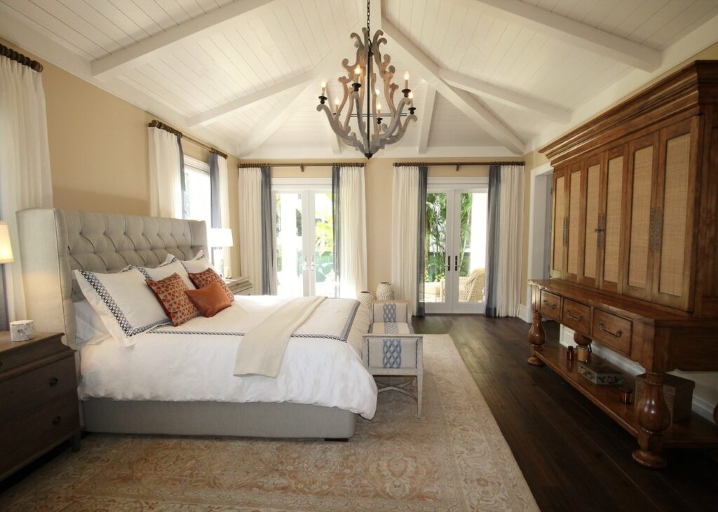 Airbnb luxury bedroom with quilted headboard, wooden light fixture and antique wardrobes
